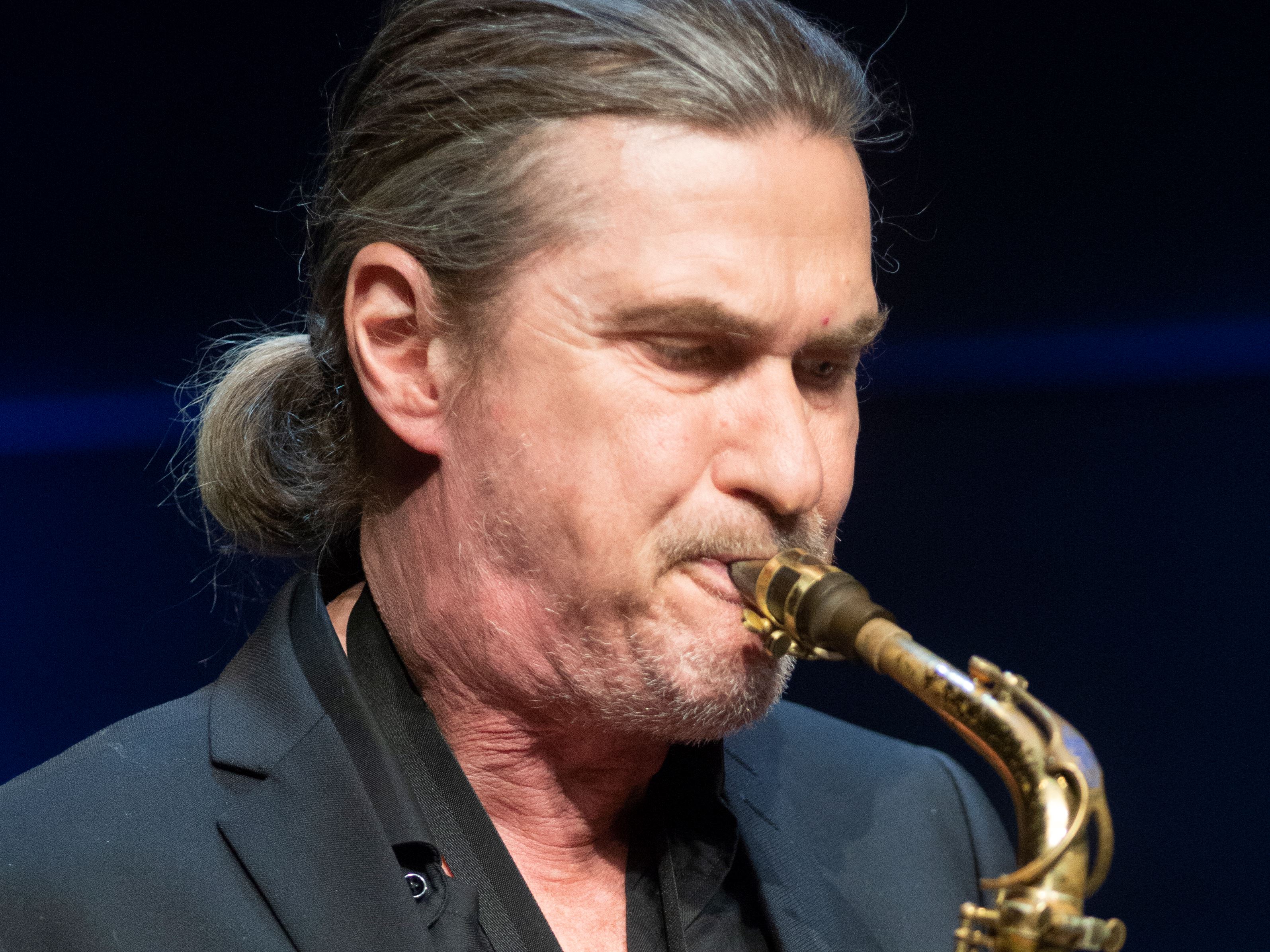 Närbild av saxofonisten Håkan Broström när han spelar saxofon.