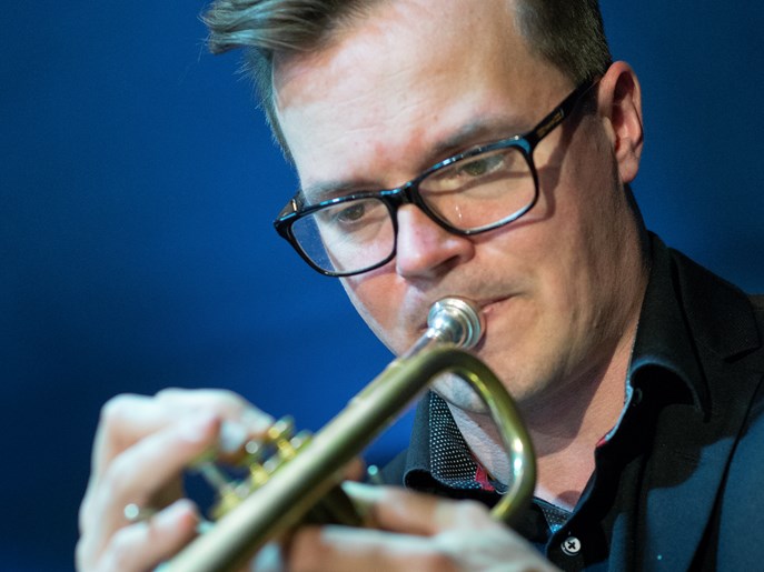 Närbild av trumpetaren Jacek Onuszkiewicz när han spelar trumpet.