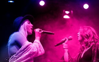 Två personer står på en scen och sjunger