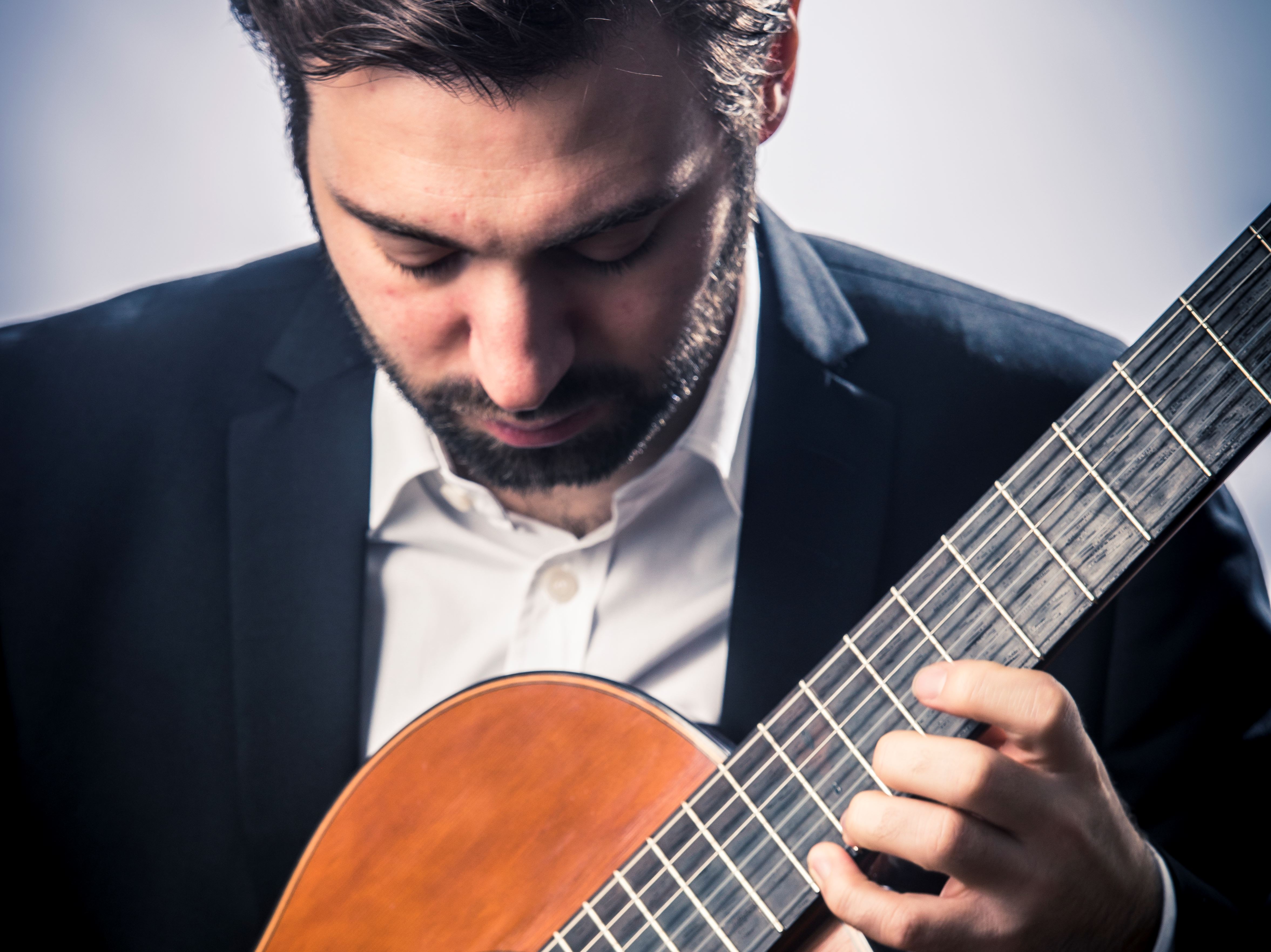 Porträttbild på musikern Jakob Kellermann. I händerna håller han en gitarr.