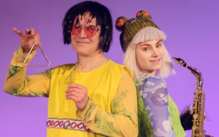 Figurerna Hasse och Helmi står i färgglada kläder mot en lila bakgrund....