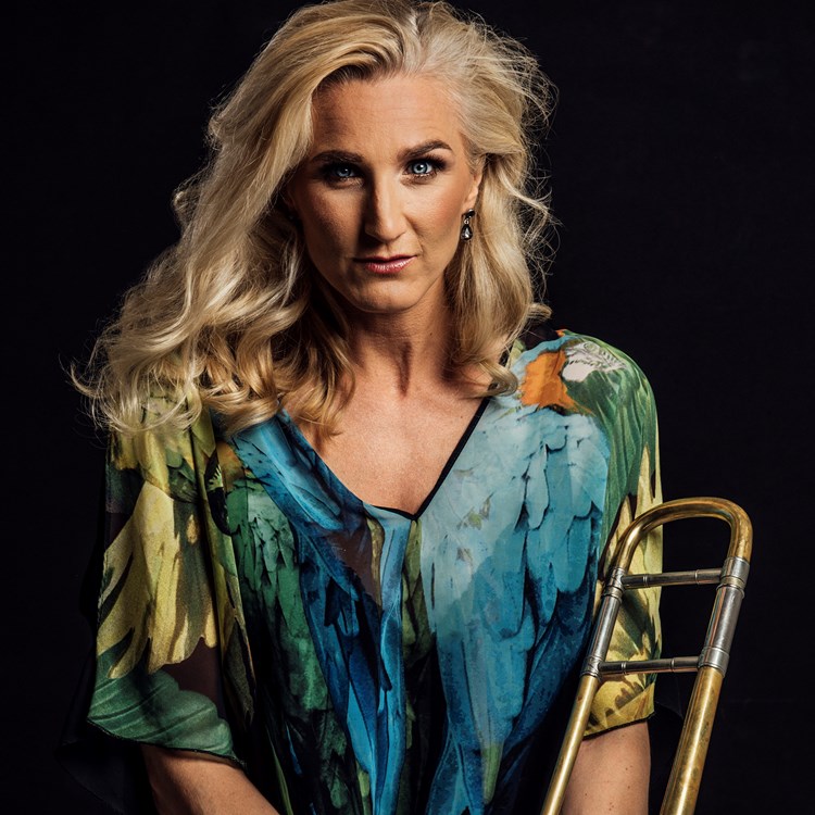 Porträttbild på trombonisten Karin Hammar hållandes en trombon.