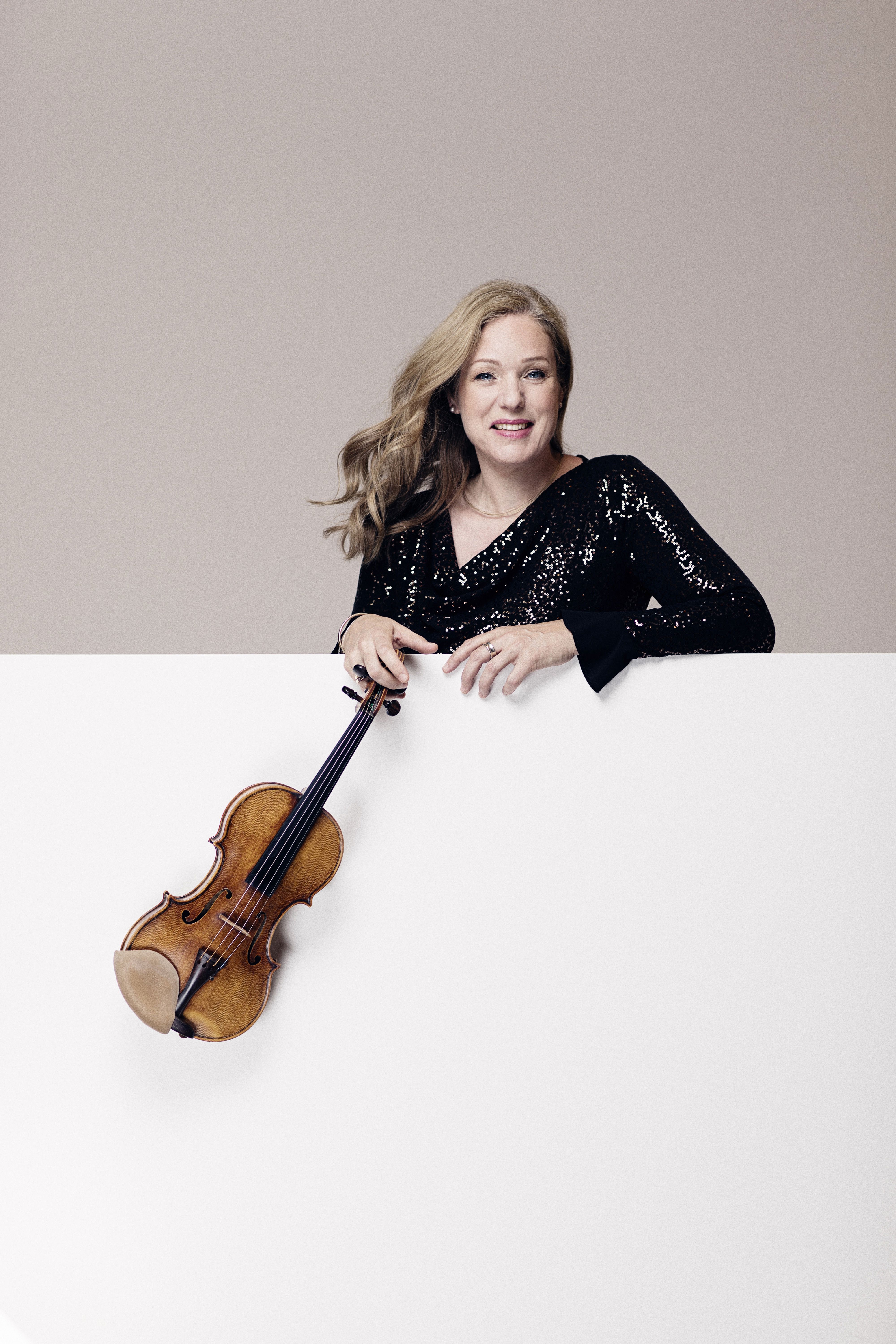 Porträttbild på violinisten Isabelle van Keulen hållandes i en violin. 